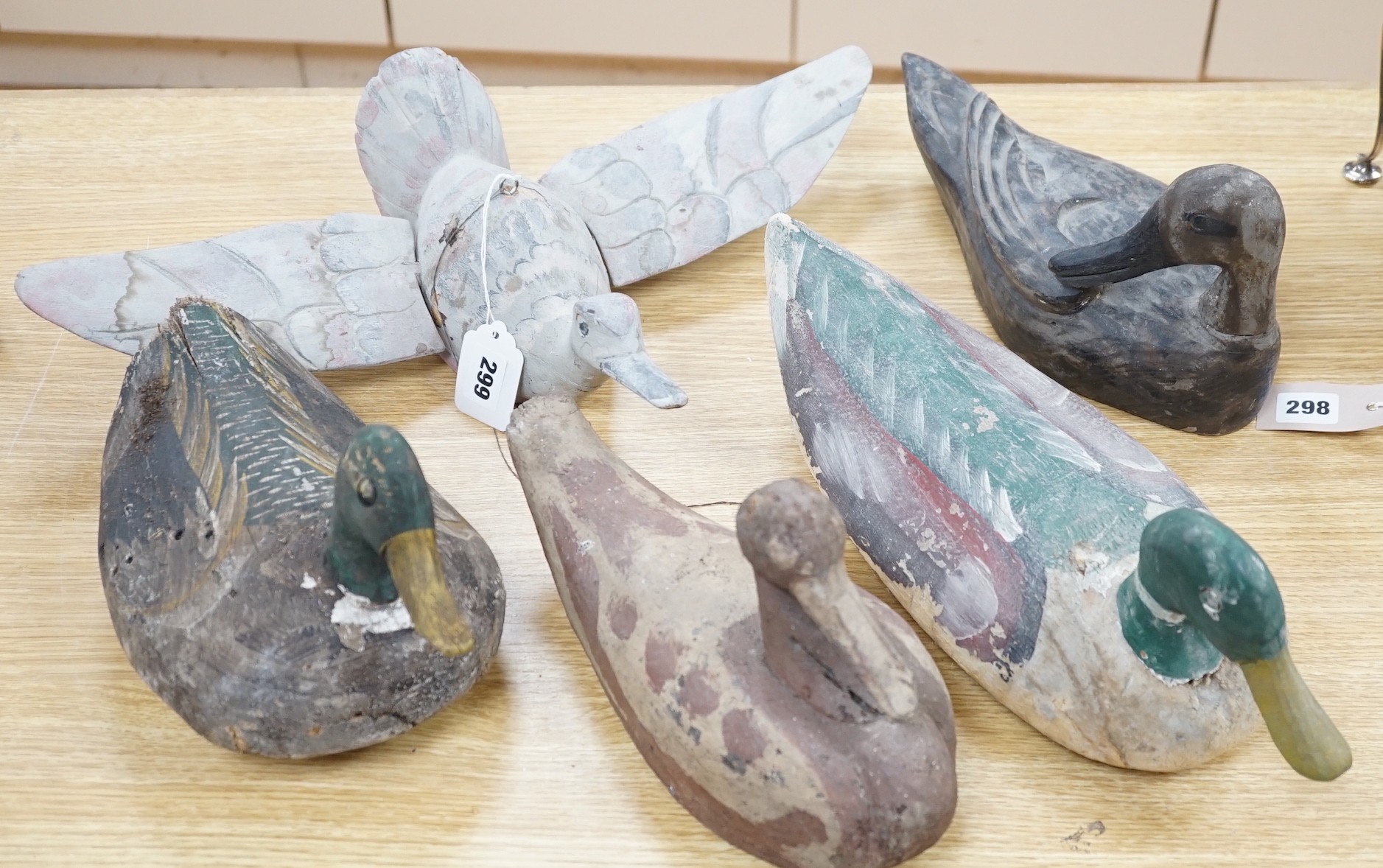 Five primitive wood decoy ducks, one in flight, longest 40cm